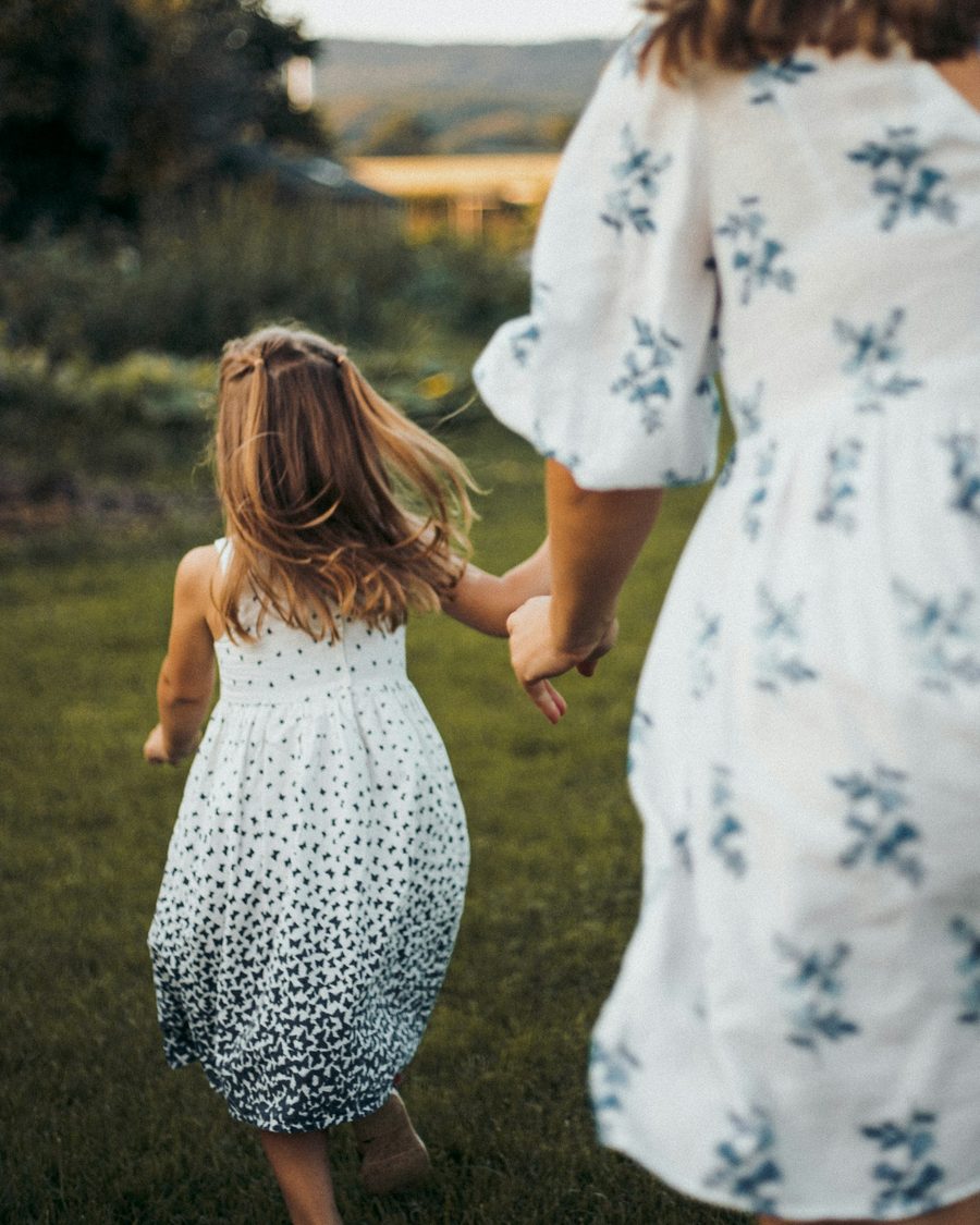 A child walking hand in hand with an adult